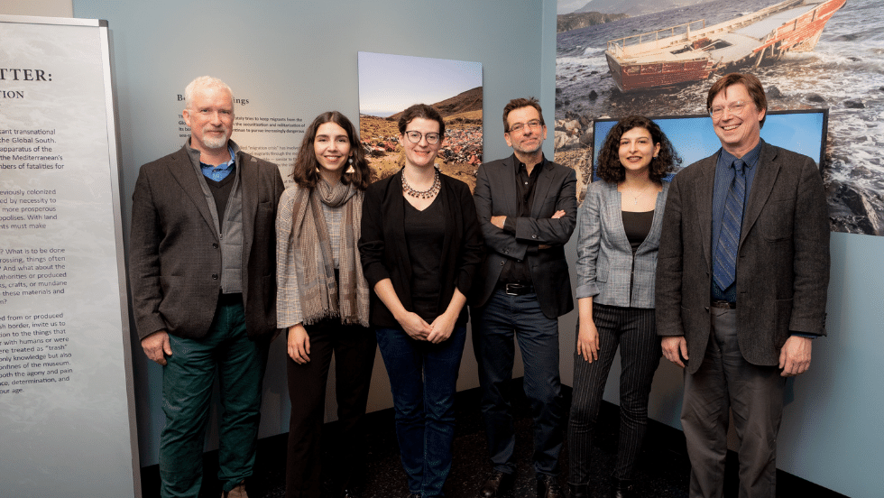 The museum director, deputy director, and five curators posing for a photo in the Transient Matter exhibit.