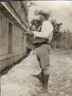 Antique black-and-white photo of Herbert J. Spinden looking at the exterior of a building.