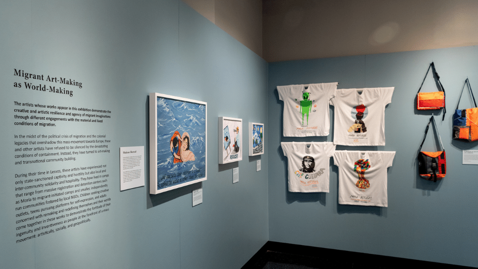 Paintings, t-shirts, and bags made by refugees on display in the exhibit. 